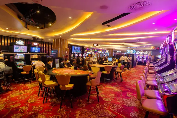 88FD App — Enjoy seamless gaming on your smartphone A young woman relaxing with her phone while dynamic casino elements float around her, illustrating the smooth mobile experience offered by the 88FD app.