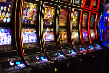 A woman smiling by bright slot machines showing lucky symbols, showcasing the exciting slot offerings at 88FD.